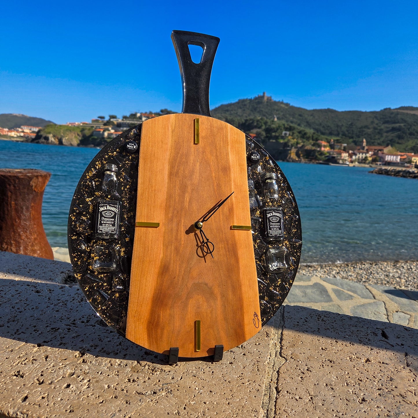 Horloge artisanale en bois de cerisier et résine noire avec mini bouteilles Jack Daniel’s, création haut de gamme faite main