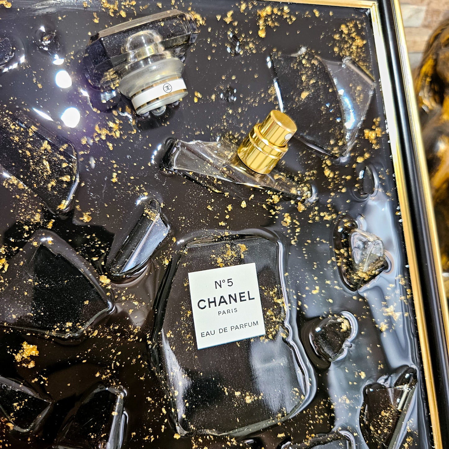 Tableau déco noir et or en résine époxy avec éclats de verre et flacon Chanel, fait main en France
